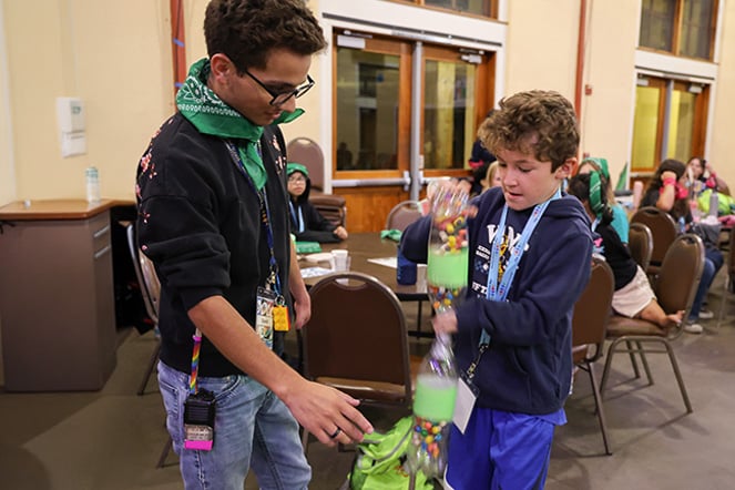 a teenager helping a child with a crafting project