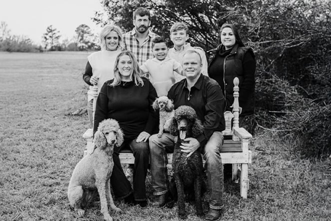 an antique photo of a family and three dogs