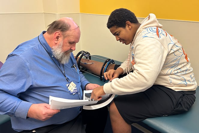 a patient with a care provider looking at printed x-rays together