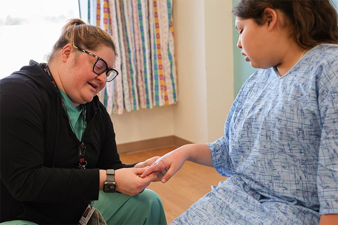 Physician examining burns on hands of patient