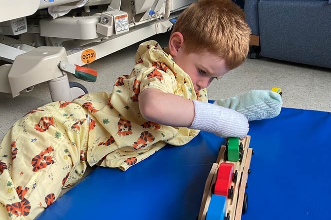 Cameron playing on floor in hospital