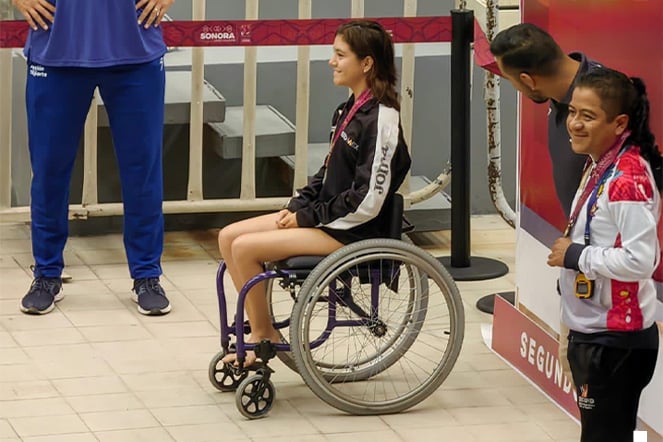 a teenager in a wheelchair at an award podium after an sporting event