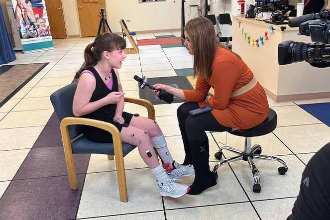 a news reporter holding a microphone interviewing a teenager