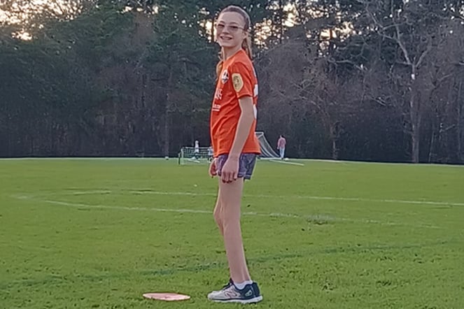 a female child standing on a soccer field