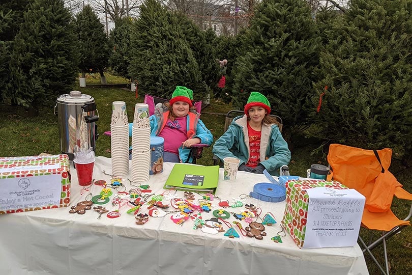 Chloe sitting at fundraiser table with friend