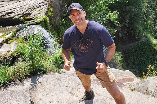 Chris standing on big rock giving thumbs up