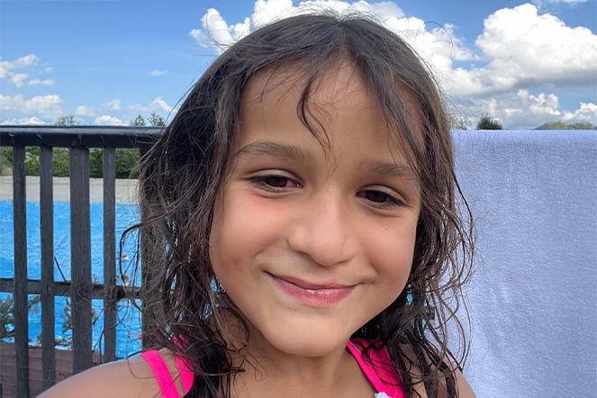 A smiling child near a pool