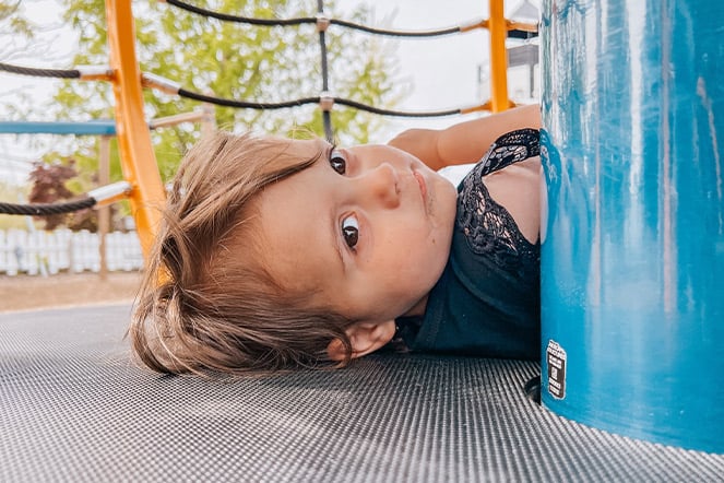 a child laying on her back at a playground