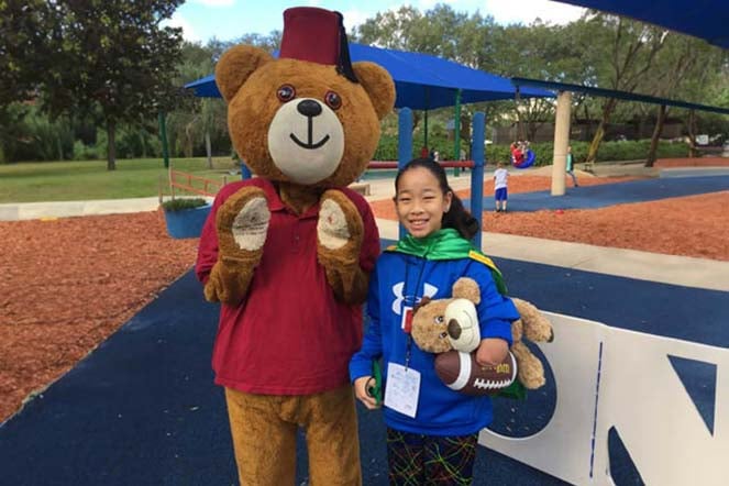 Danielle on playground with Fezzy bear