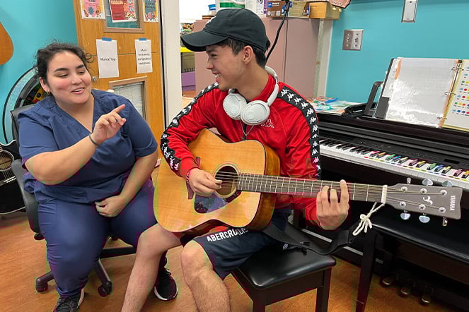 Elian playing guitar with Angie.