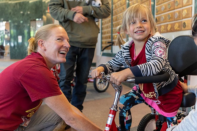 Elly on bike, with therapist