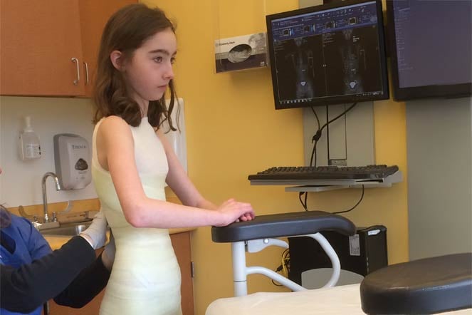 Female patient being fitted for a back brace