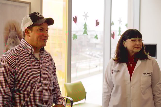 an adult and care provider looking in the same direction off camera