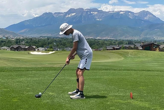 patient on gold course teeing up the ball