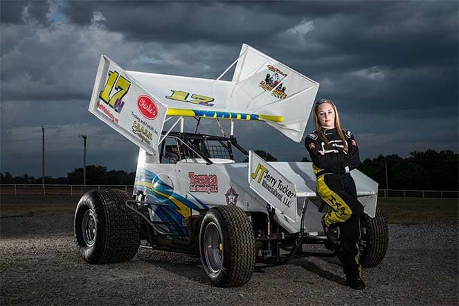 Harli standing next to her car