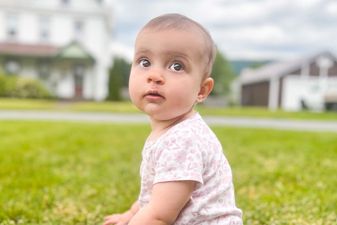 an infant on a grassy lawn