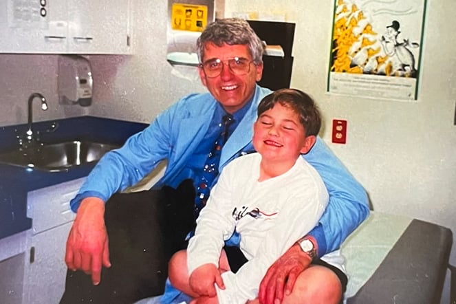a vintage photo of an adult smiling with his arm around a smiling child