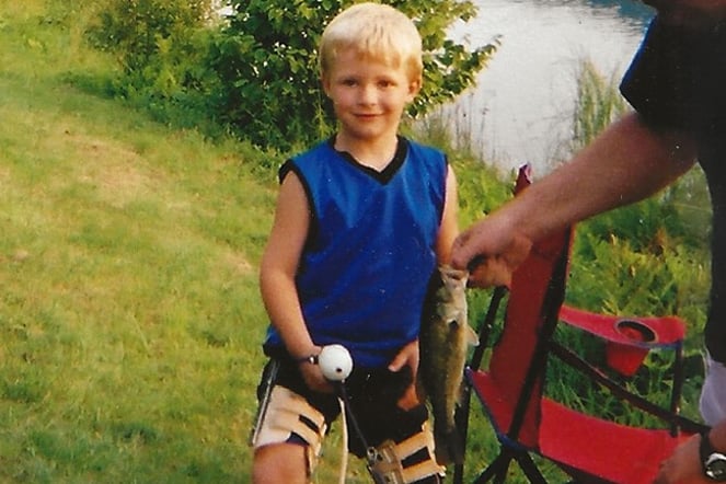 a child with leg braces holding a fish