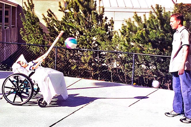 limb length discrepancy patient and an adult playing a modified game of baseball with a plastic pole and beach ball
