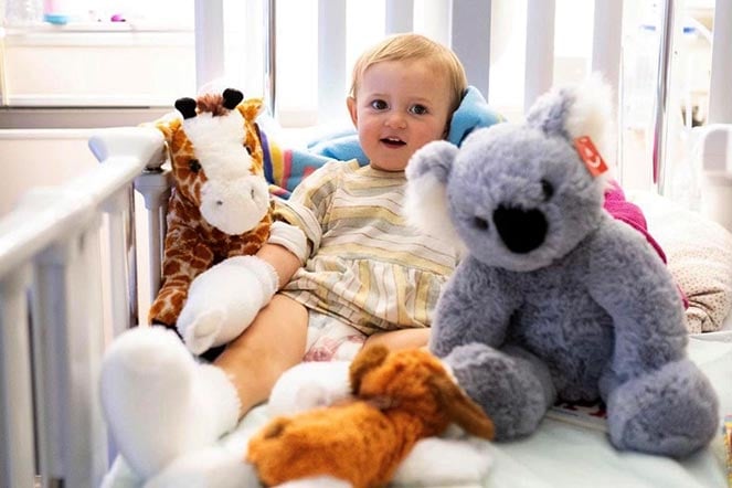 Lina in crib surrounded by stuffed animals