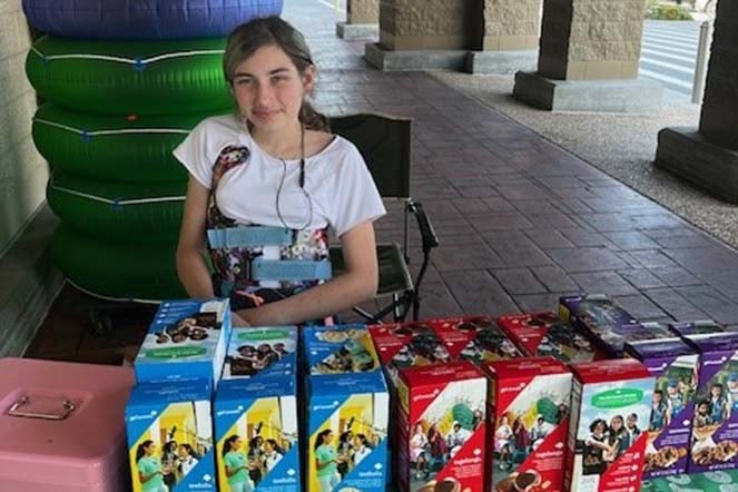 female scoliosis patient selling girl scout cookies