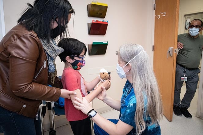 Myles, his mother and staff members during prosthesis fitting