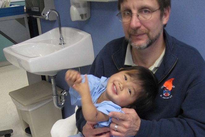 A very young Natalie held by dad