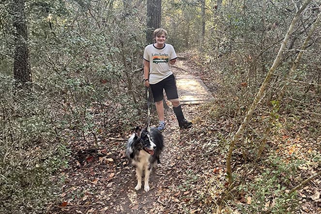 Nathanial on a hiking trail with his medium-sized dog, Chewie.