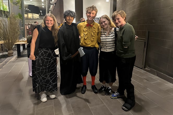 Nathanial and three friends arranged in a group photo in the lobby of a theater.