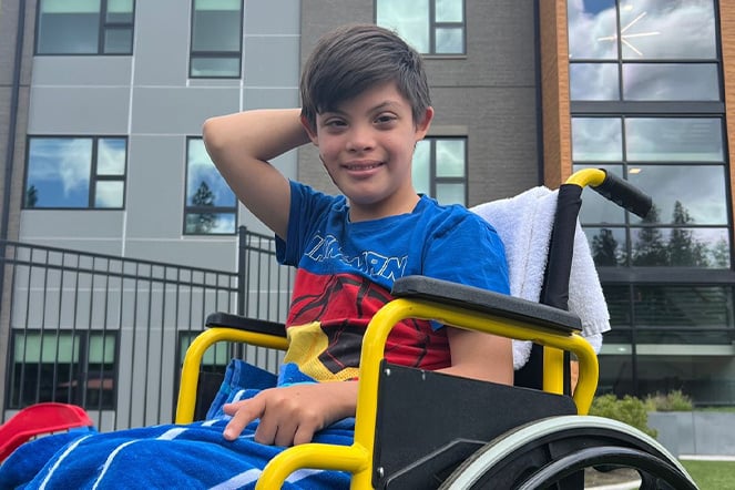 a child in a wheelchair in front of a building