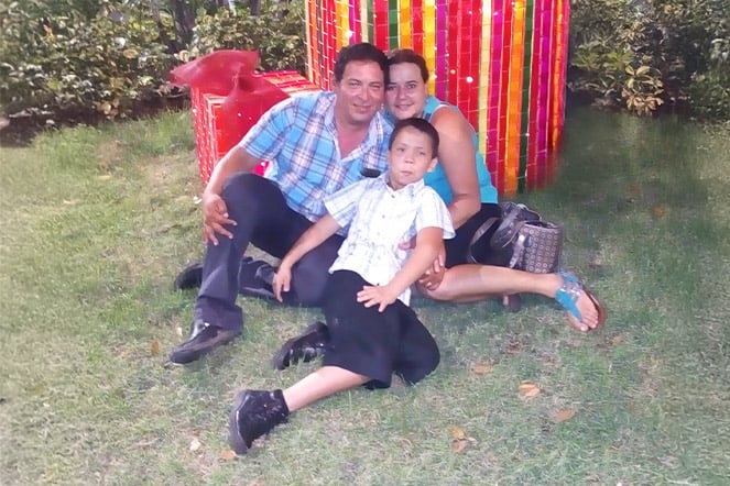 a family sitting together in front of a large wrapped present