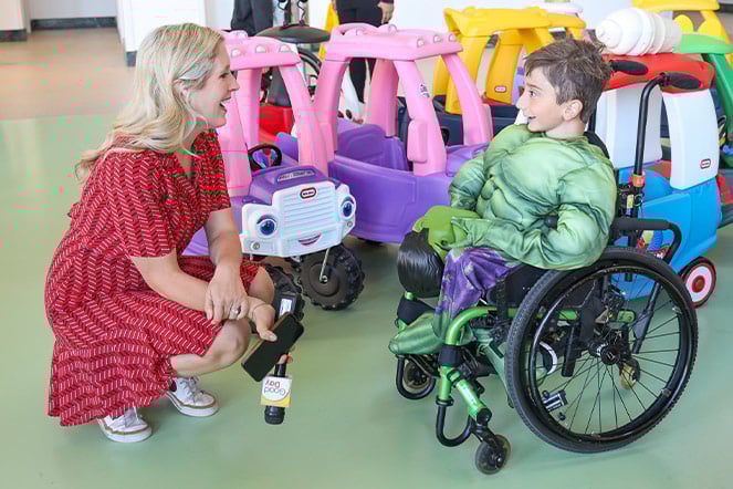a child in a wheelchair speaking with an adult