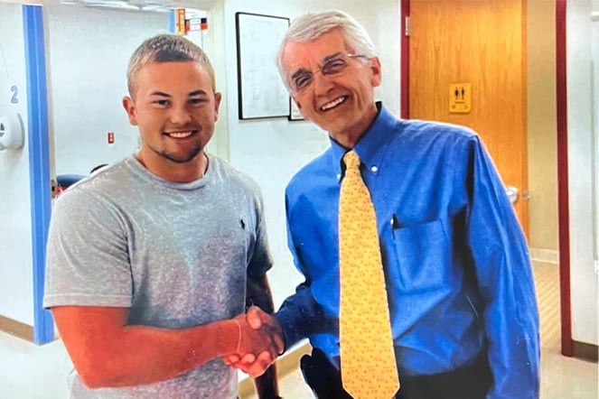 two men smiling and shaking hands