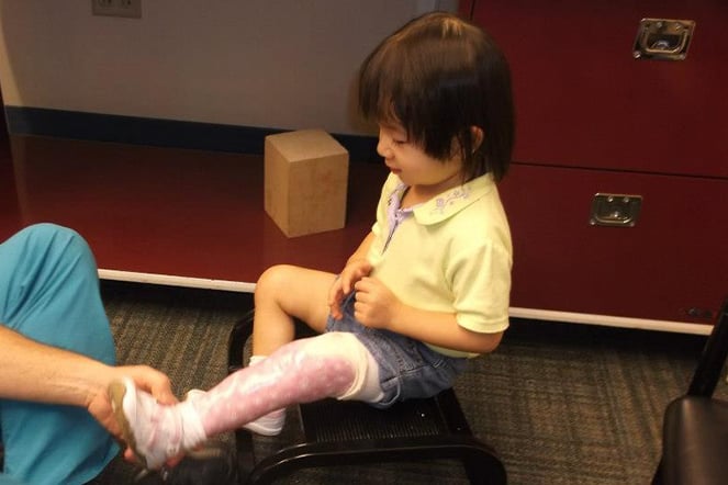 a young child being fitted for a prosthetic leg