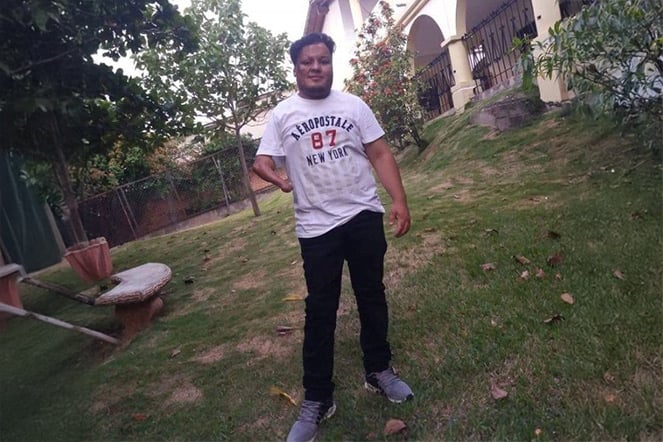 Patient Josue standing on a lawn.