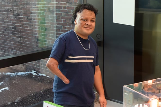 Patient Josue smiling in front of a science exhibit.