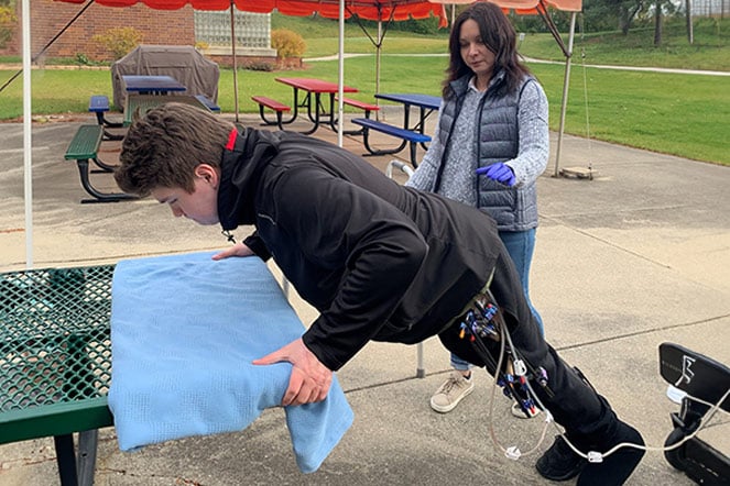 Patient doing chest presses with physical therapist