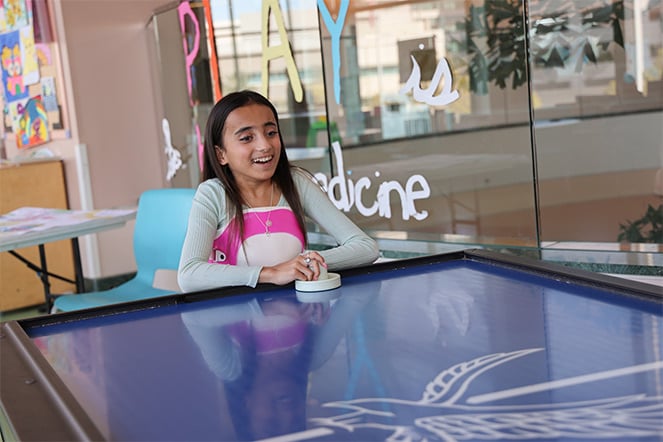 Patient in back brace playing air hockey