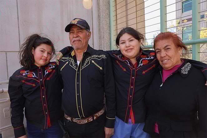 Female patient standing next to mother, father and sister