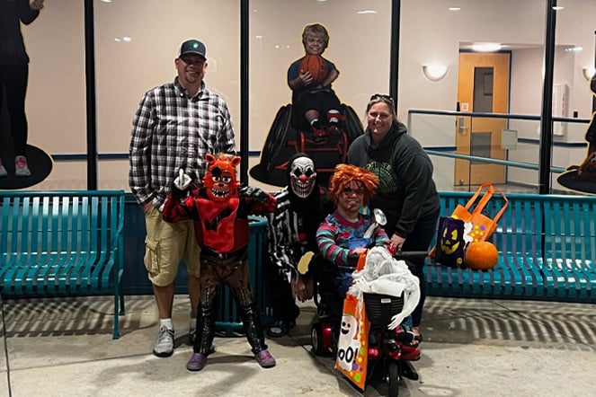 a group of adults and children in Halloween costumes