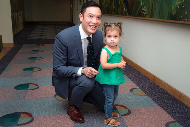a child and a smiling man in a suit