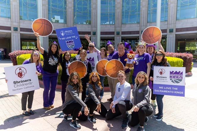 emmy with the Sacramento dance team, Shriners Children's Northern California logo, We love the Sacramento Kings sign, Sacramento Kings logo