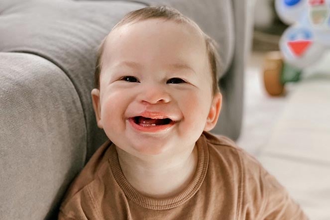Saint sitting on floor with big smile