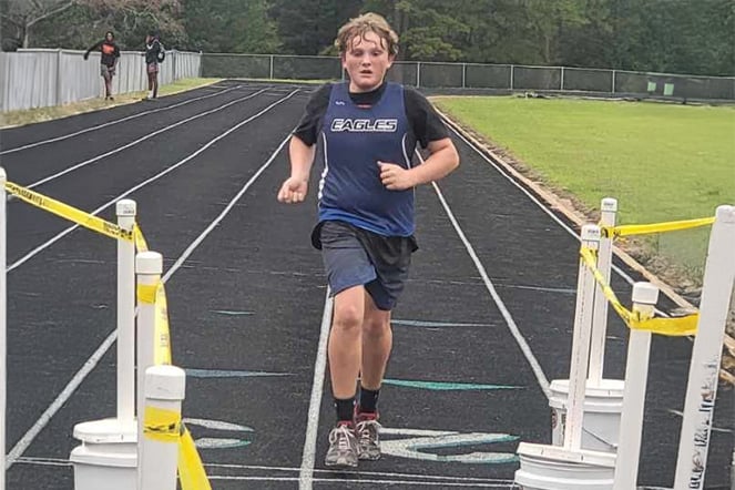 a teenager running on a track