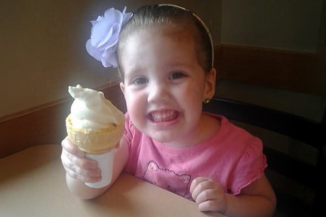 a young child smiling with an ice cream cone