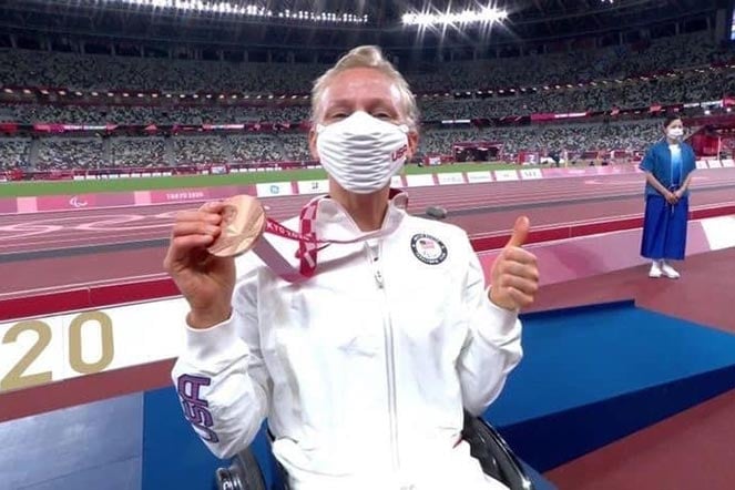Susannah holding gold medal at Paralympic Games