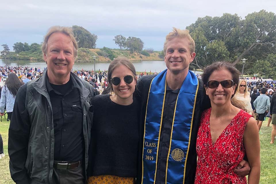Tommy smiling with his family at graduation