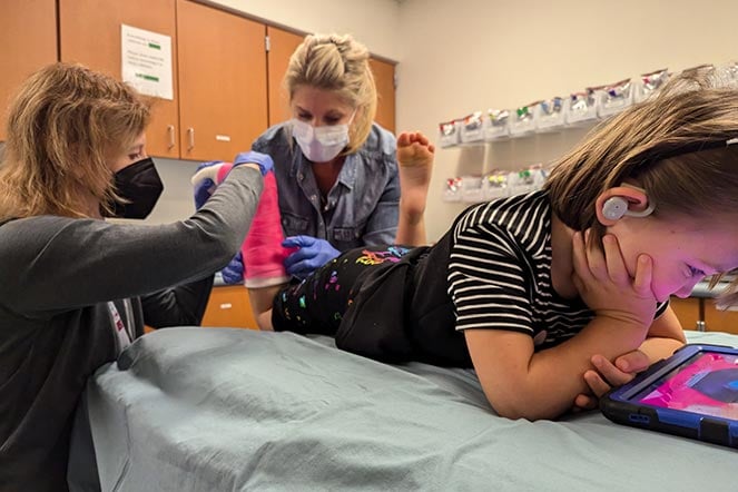 two female providers remove leg casts