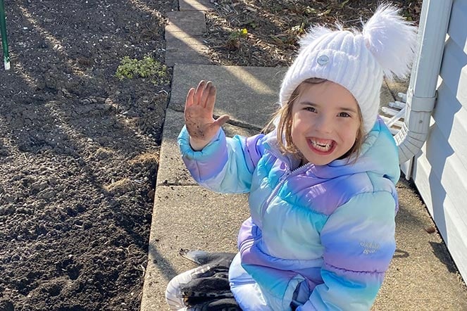 veronica outside waving in her coat