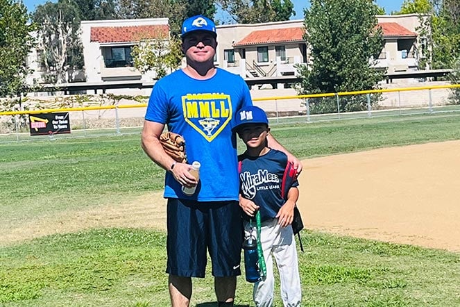 Weston with father on baseball field, Weston's shirt text: "Mira Mesa Little League"